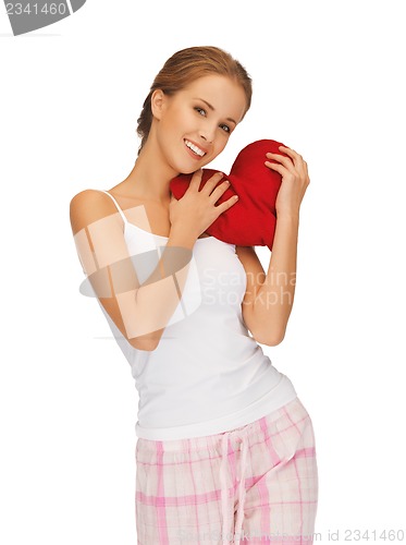 Image of happy and smiling woman with heart-shaped pillow