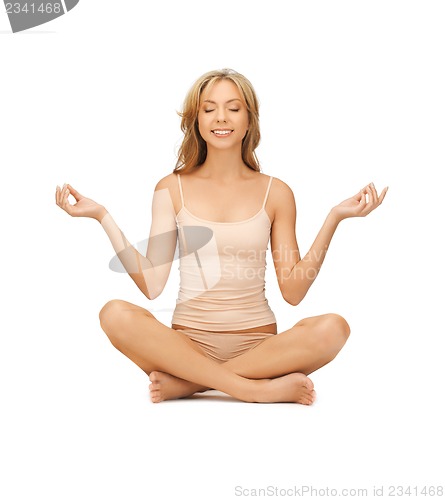 Image of woman in undrewear practicing yoga lotus pose