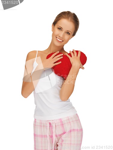 Image of happy and smiling woman with heart-shaped pillow