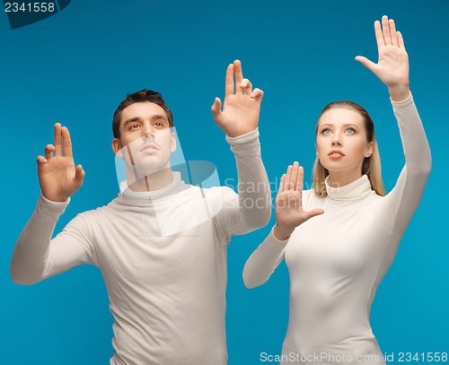 Image of man and woman working with something imaginary