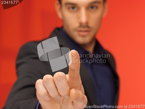 Image of handsome man in suit pressing virtual button