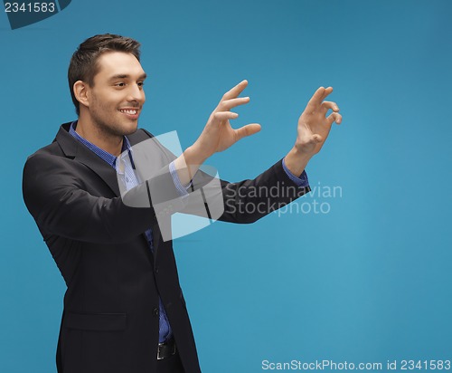 Image of man in suit working with something imaginary