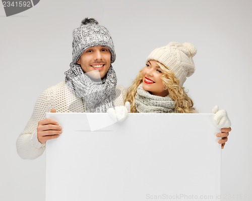 Image of couple in a winter clothes holding blank board