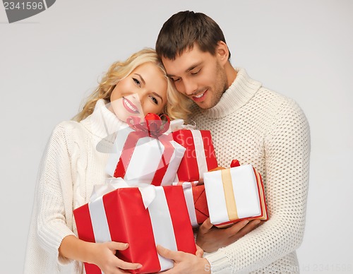 Image of romantic couple in a sweaters with gift boxes