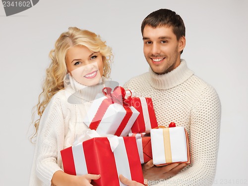 Image of family couple in a sweaters with gift boxes