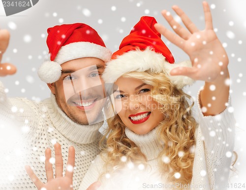 Image of family couple in sweaters and santa's hats