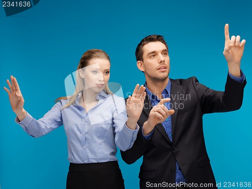 Image of man and woman working with something imaginary