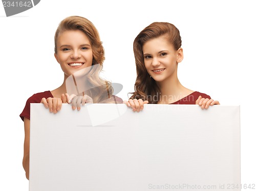 Image of two teenage girls in red dresses with blank board
