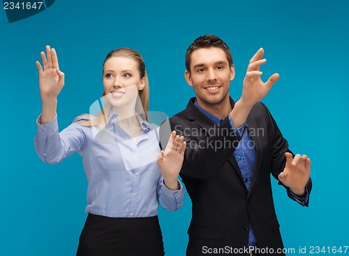 Image of man and woman working with something imaginary