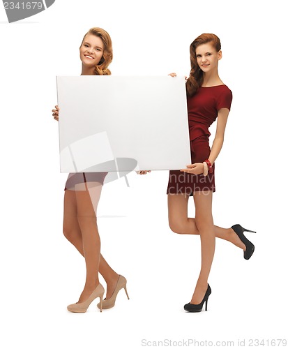 Image of two teenage girls in red dresses with blank board