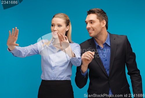 Image of man and woman working with something imaginary