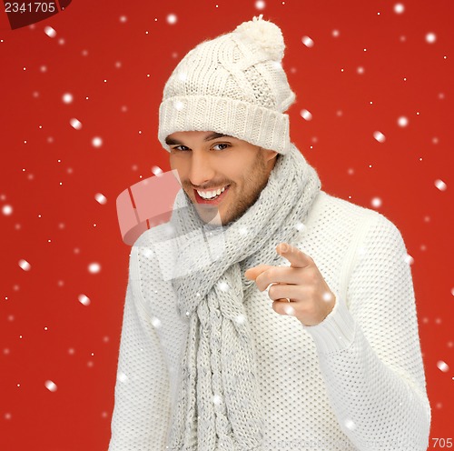 Image of handsome man pointing his finger with snow