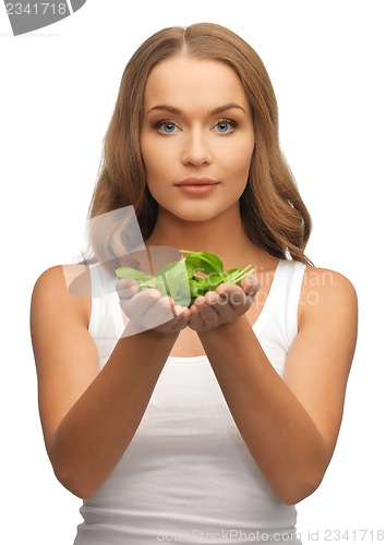 Image of woman with spinach leaves on palms