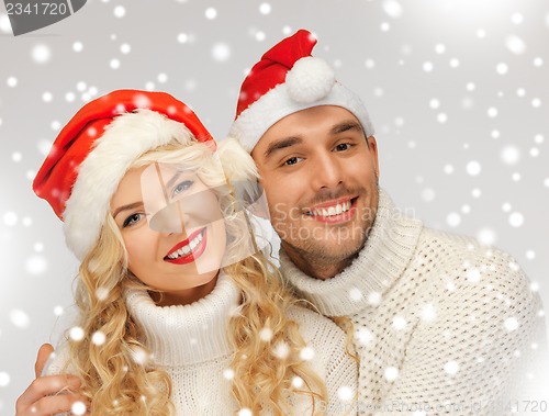 Image of family couple in sweaters and santa's hats