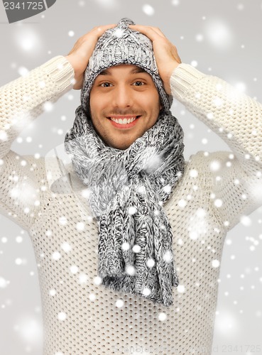 Image of handsome man in warm sweater, hat and scarf