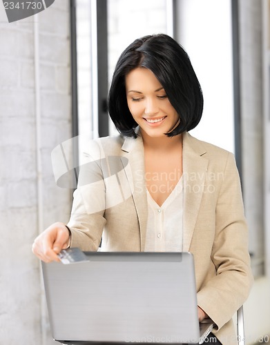 Image of happy woman with laptop computer and credit card