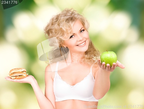 Image of woman choosing between burger and apple