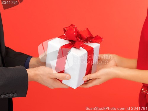 Image of man and woman's hands with gift box