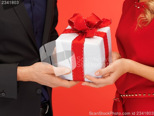 Image of man and woman's hands with gift box