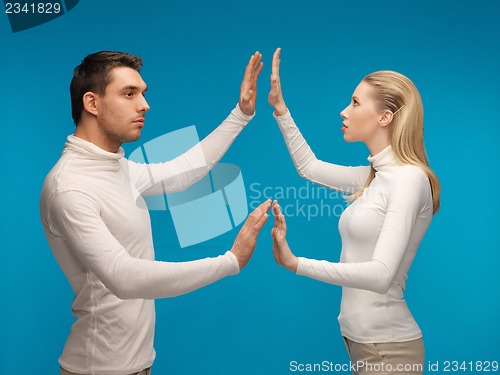 Image of man and woman working with something imaginary