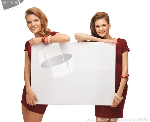 Image of two teenage girls in red dresses with blank board