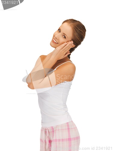 Image of woman in cotton pajamas making sleeping gesture