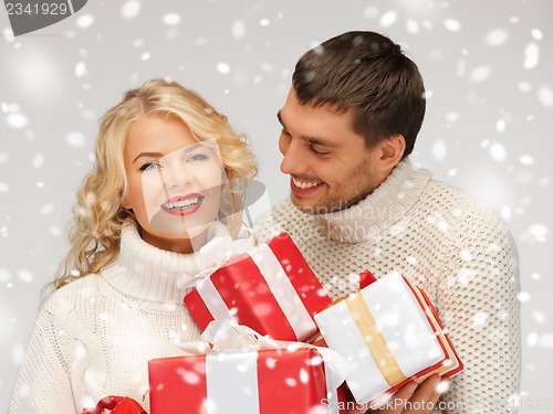 Image of family couple in a sweaters with gift boxes