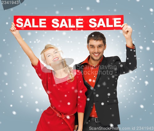 Image of man and woman with sale sign