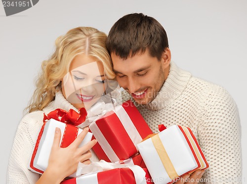 Image of romantic couple in a sweaters with gift boxes