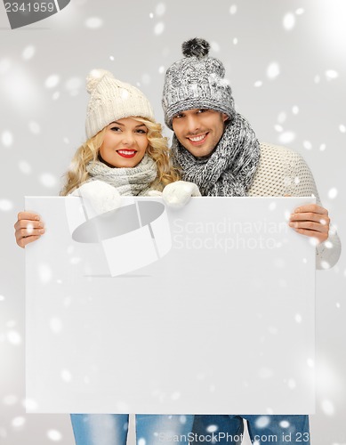 Image of couple in a winter clothes holding blank board