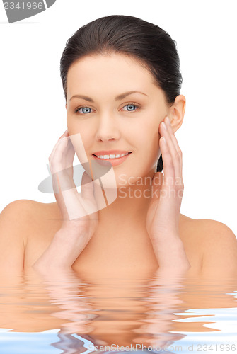 Image of face and hands of beautiful woman in water