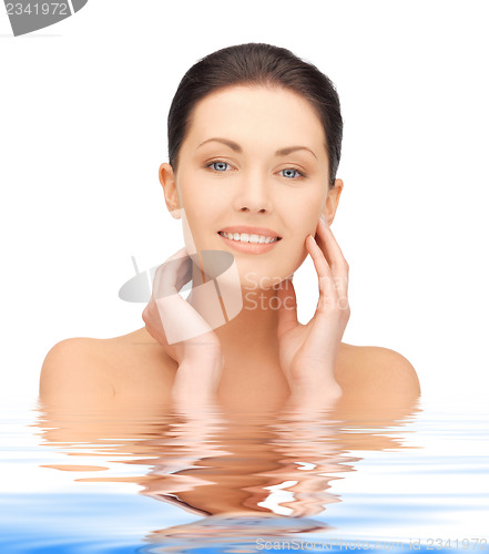 Image of face and hands of beautiful woman in water