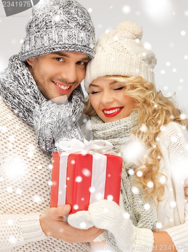 Image of romantic couple in a sweaters with gift box