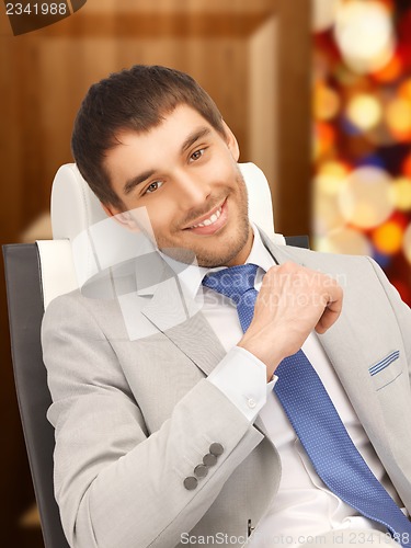 Image of young businessman sitting in chair