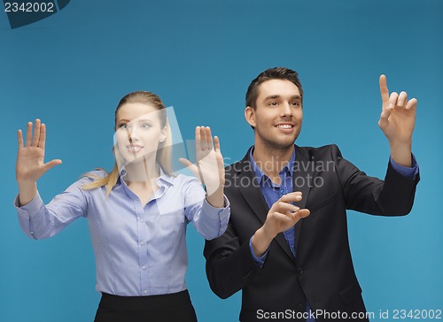 Image of man and woman working with something imaginary