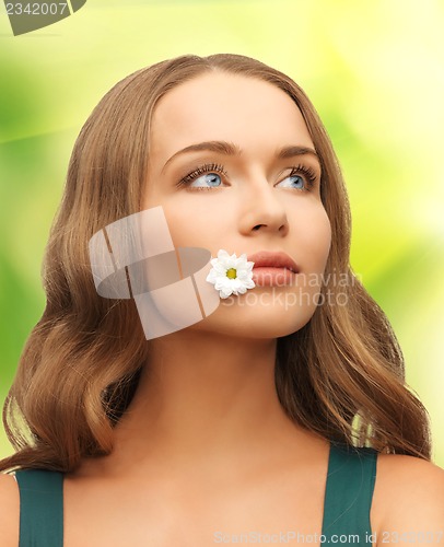 Image of woman with camomile in mouth