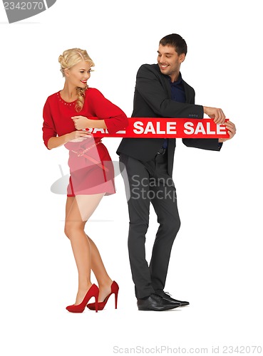 Image of man and woman with sale sign