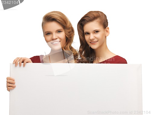 Image of two teenage girls in red dresses with blank board