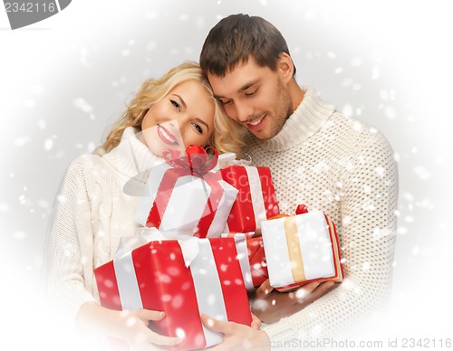 Image of romantic couple in a sweaters with gift boxes