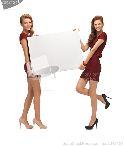 Image of two teenage girls in red dresses with blank board