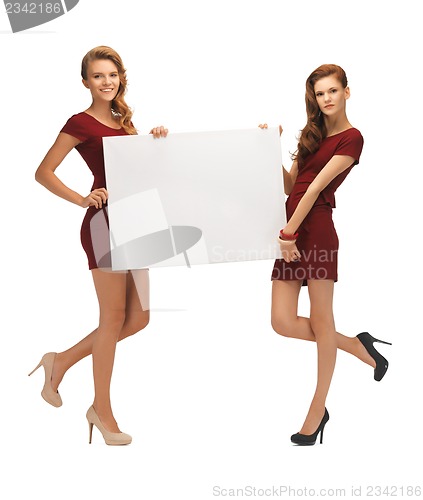 Image of two teenage girls in red dresses with blank board