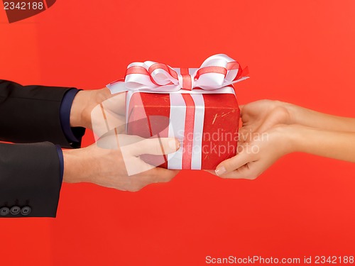 Image of man and woman's hands with gift box