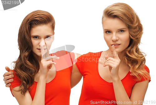 Image of two teenage girls showing hush gesture