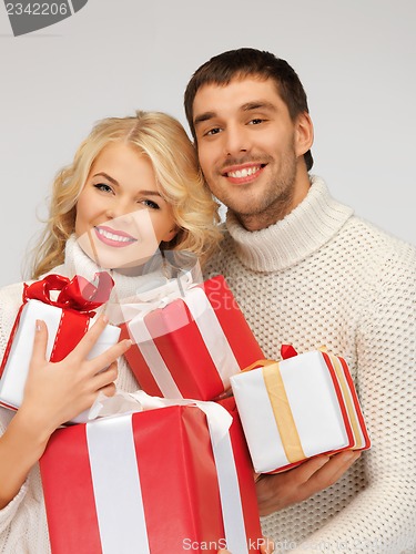 Image of family couple in a sweaters with gift boxes