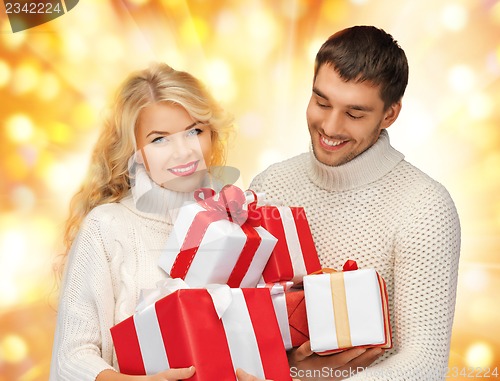 Image of family couple in a sweaters with gift boxes