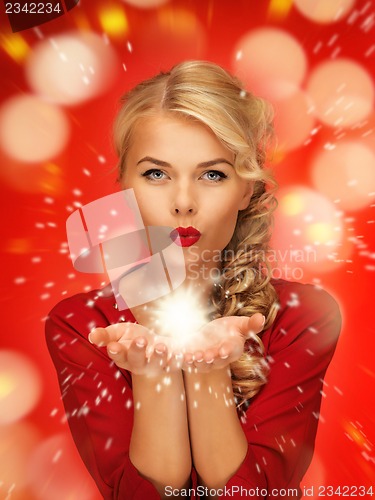 Image of woman blowing magic on the palms of her hands