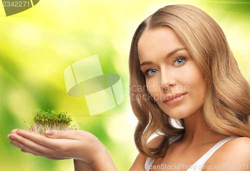 Image of woman with green grass on palms