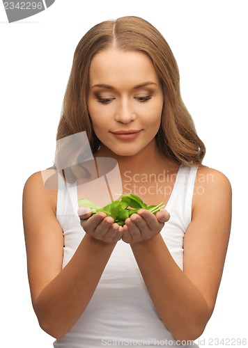 Image of woman with spinach leaves on palms