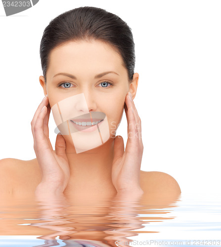 Image of face and hands of beautiful woman in water