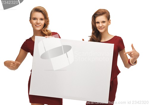 Image of two teenage girls in red dresses with blank board